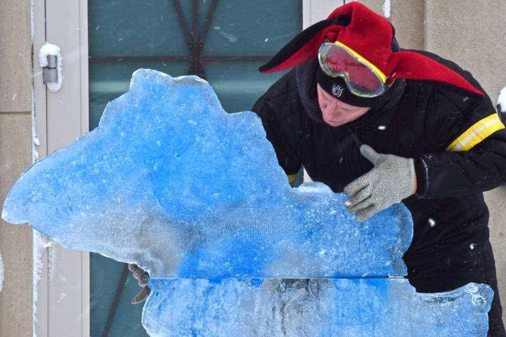person leaning over michigan ice sculpture